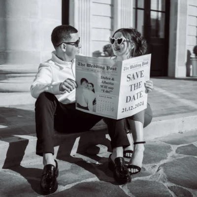 Engaged couple holding a Save the Date newspaper for their wedding.